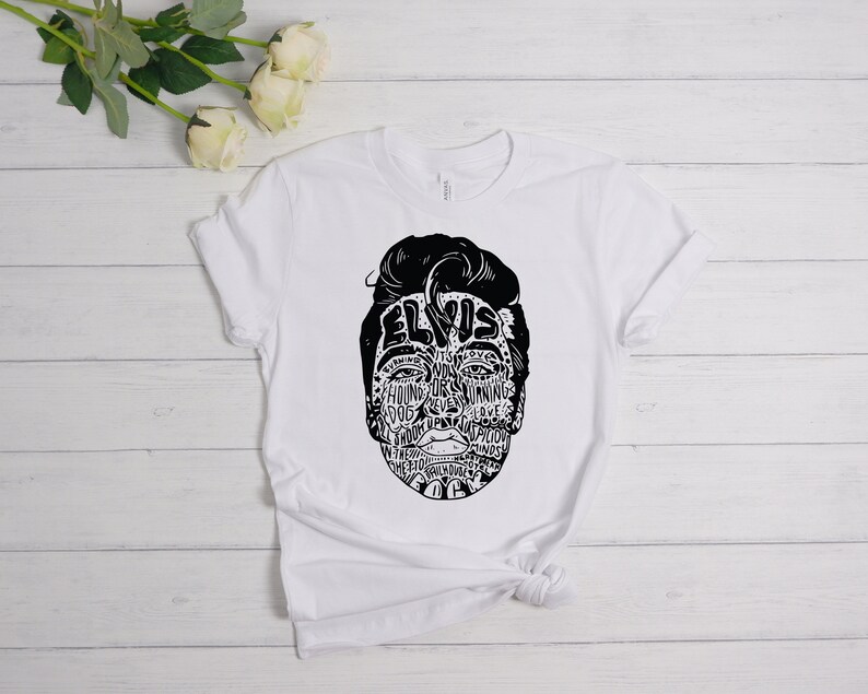 May include: White t-shirt with a black and white graphic of Elvis Presley's face made up of words related to his music and career. The words include "Hound Dog", "Jailhouse Rock", "Love Me Tender", and "Can't Help Falling in Love".