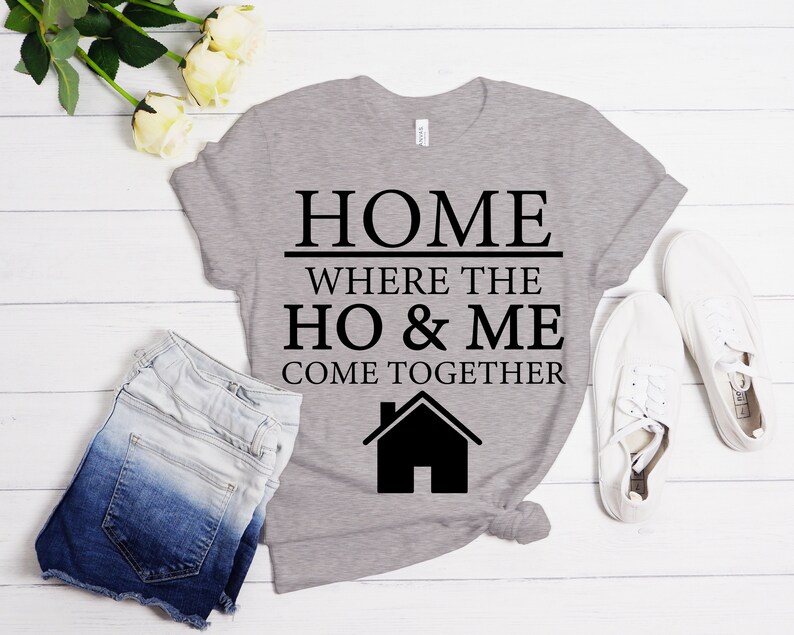 May include: A gray t-shirt with black text that reads "HOME WHERE THE HO & ME COME TOGETHER" and a black house icon.