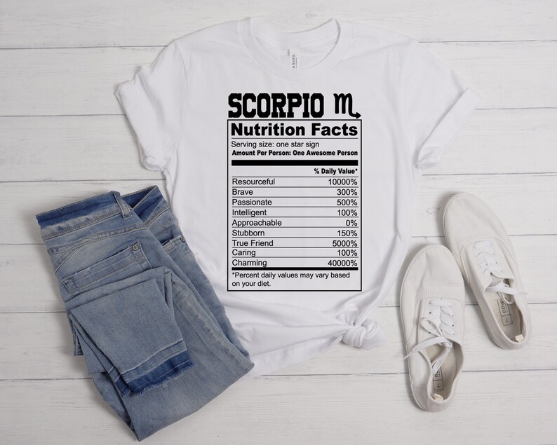 May include: White t-shirt with a black graphic of a nutrition facts label for a Scorpio. The label lists traits like resourceful, brave, passionate, intelligent, approachable, stubborn, true friend, caring, and charming with a percentage value for each.