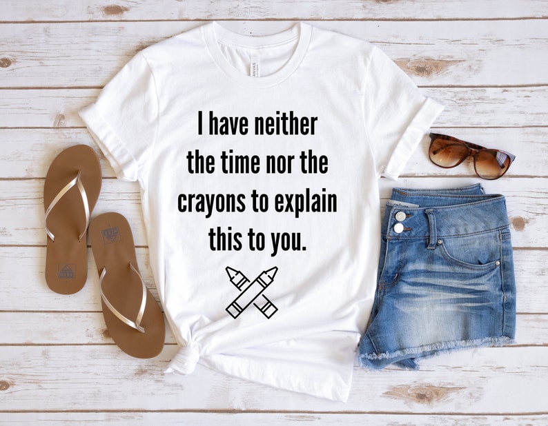 May include: White t-shirt with a black graphic that says "I have neither the time nor the crayons to explain this to you." and a pair of crossed crayons.