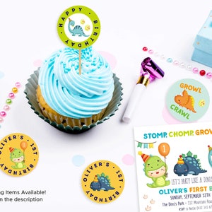 May include: A set of dinosaur-themed party decorations for a first birthday. The set includes a cupcake topper, a round sticker with a dinosaur and the text "Oliver's 1st Birthday", a round sticker with the text "Growl Crawl", and a party invitation with the text "Stomp, Chomp, Growl & Crawl. Let's party like a dinosaur and celebrate Oliver's First Birthday. Sunday, September 12th 2020 at 2pm. The Dino's Park - 112 Mountain Road, Birdsville QLD 445. RSVP to Nellie 0412 345 678 by 09/03."