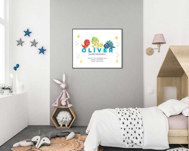 May include: A white and blue dinosaur themed baby announcement print with the name "Oliver James Russell" and the date "Sunday, 15th September 2019".