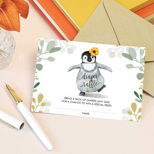 May include: A white card with a green and gold floral design. A cartoon penguin wearing a lei and a yellow flower is dancing. The text "diaper raffle" is written in cursive. The text "Bring a pack of nappies (any size) for a chance to win a special prize!" is written below the penguin. The text "Name" is written at the bottom of the card.