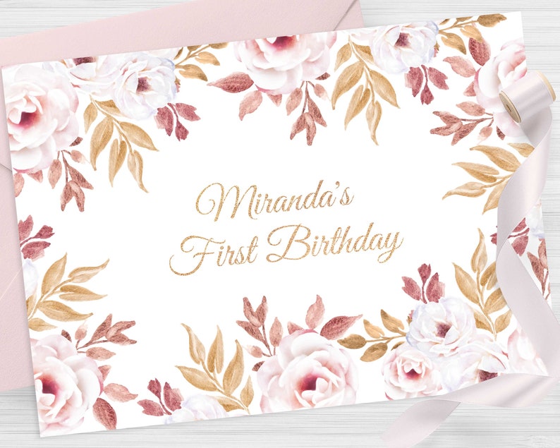Pu&ograve; includere: Un biglietto bianco con un bordo floreale dorato e il testo "Miranda's First Birthday" in lettere dorate scintillanti.
