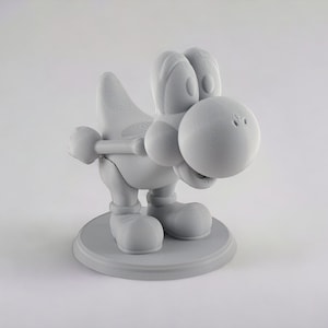 May include: A 3D printed figurine of a gray Yoshi, a dinosaur-like character from the Super Mario video game franchise. The figurine is posed in a crouching position with its head tilted down and its mouth slightly open. The figurine is standing on a circular base.