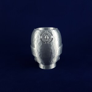 May include: A white ceramic planter with a textured surface and a geometric design. The planter has a round shape and a wide opening.