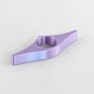 Peut inclure: Un marque-page en plastique violet en forme de livre. Le marque-page a un trou au centre pour maintenir une page.