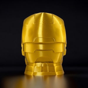 K&ouml;nnte beinhalten: Eine goldfarbene, 3D-gedruckte B&uuml;ste eines Roboterkopfes mit Visier.
