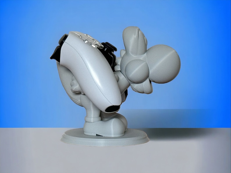 May include: A white 3D printed figurine of a gray Yoshi holding a white video game controller. The Yoshi is standing on a round base.