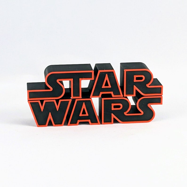 May include: Black 3D plastic "Star Wars" logo with red outline.