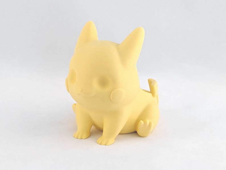 May include: A yellow Pikachu-shaped planter made of plastic. The planter is sitting on a white surface.