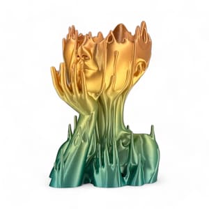 May include: A gold and green abstract sculpture of a human head with flowing lines and a vase-like opening at the top.
