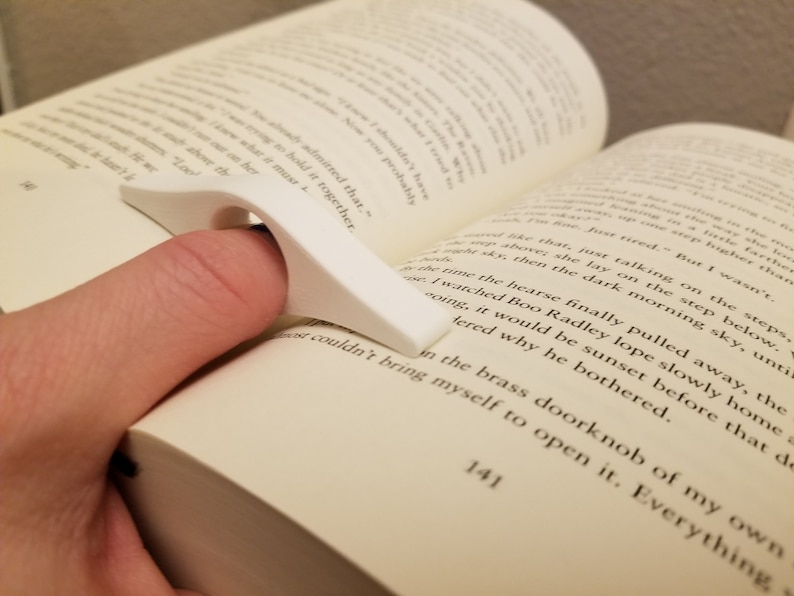 Peut inclure: Un porte-page en plastique blanc pour un livre. Le porte-page est con&ccedil;u pour s'adapter &agrave; un doigt et maintenir la page en place pendant la lecture.
