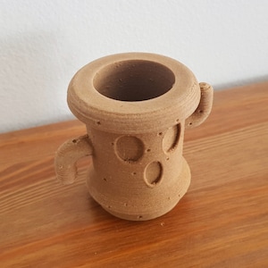 May include: A brown 3D printed cactus planter with two small arms and a textured surface.