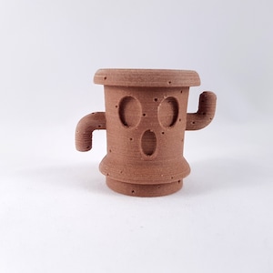 May include: A brown 3D printed cactus planter with a face and two arms. The planter has a textured surface and a hole in the top for drainage.