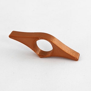 Peut inclure: Un marque-page en plastique brun avec un anneau pour maintenir une page. Le marque-page a la forme d'une lame incurv&eacute;e et pointue.