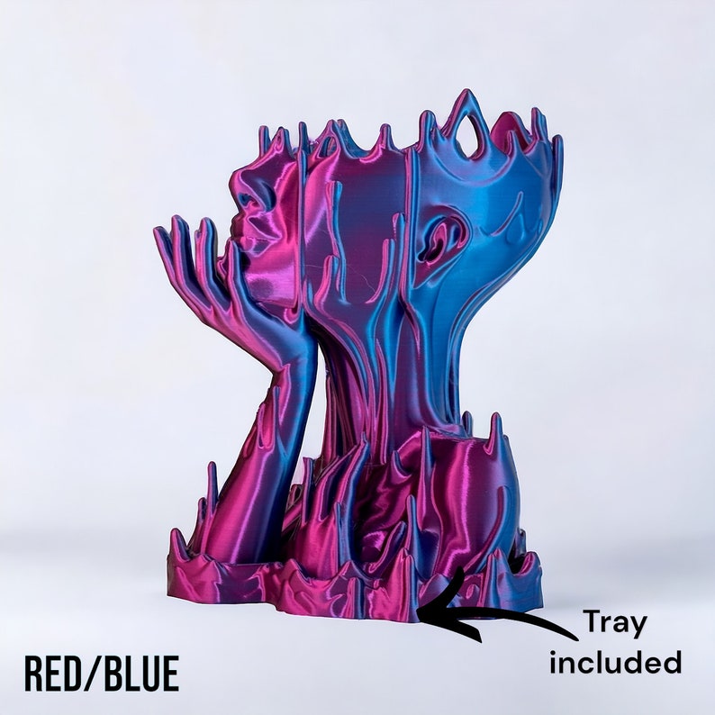 May include: A red and blue abstract sculpture of a face with a tray included. The sculpture is made of a smooth, shiny material and has a flowing, organic shape.