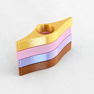 Peut inclure: Un ensemble de trois marque-pages en or, rose et violet. Les marque-pages sont en forme de goutte d'eau avec un trou au centre.