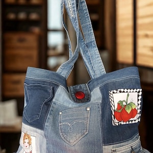 Peut inclure: Un sac fourre-tout en denim patchwork avec une fermeture à bouton rouge et des bretelles en denim. Le sac présente une variété de délavages de denim et comprend une poche et des écussons décoratifs avec des illustrations de fraises et une femme.
