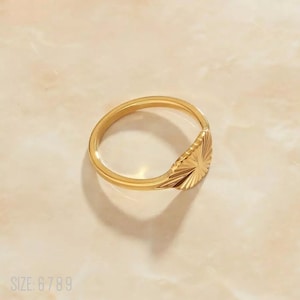 Anillo tipo sello con rayos de sol minimalistas en oro