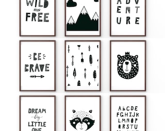 May include: Nine black and white framed prints with various designs. The prints include text such as "Wild and Free", "Be Brave", "Dream Big Little One", and "Adventure". Other prints feature a bear, a raccoon, mountains, and arrows.