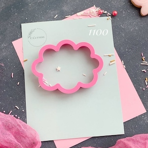 May include: Pink plastic cloud cookie cutter on a light blue background with the text "U. Cutters" and "1100".