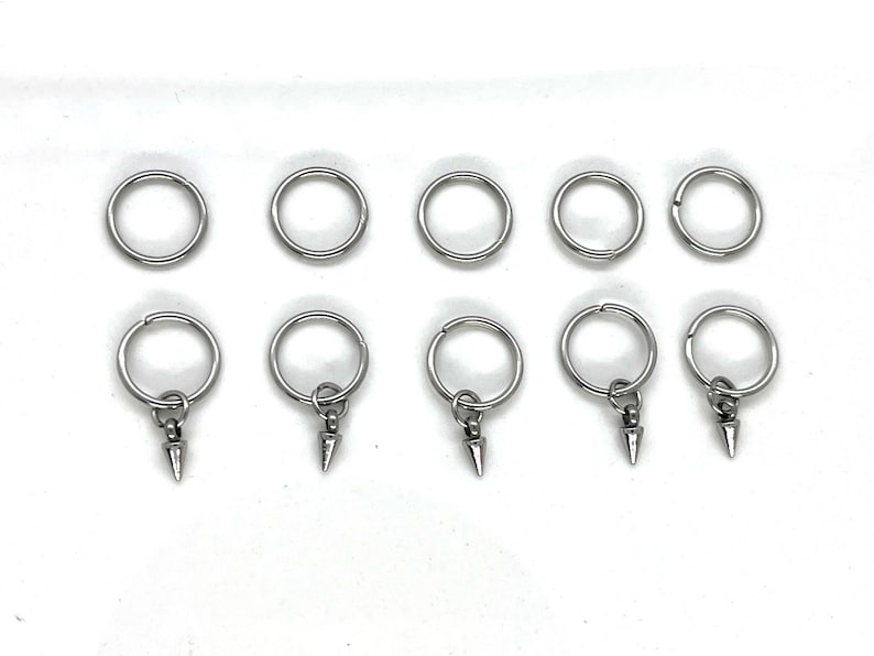 K&ouml;nnte beinhalten: Zehn silberne Schl&uuml;sselringe mit einem spitzen Metallanh&auml;nger an jedem Ring.