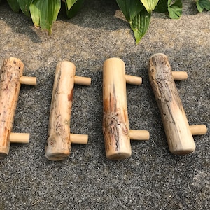 May include: Four wooden log handles with small wooden knobs on each end. The logs are rough and have a natural bark texture.