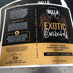 Pu&ograve; includere: Un'etichetta rettangolare per il prodotto Bella Bay Exotic Dark Sunless Tanning Mousse. Il design nero e oro presenta ali d'angelo, il nome del prodotto, ingredienti, istruzioni per l'uso e avvertenze. Include il testo 200 ML.
