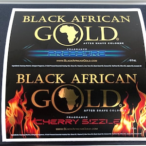 Pu&ograve; includere: Due etichette rettangolari per il dopobarba Black African Gold. L'etichetta superiore presenta la scritta Pressure con effetti di luce blu. L'etichetta inferiore mostra una grafica con fiamme e la scritta Cherry Sizzle. Entrambe elencano gli ingredienti.