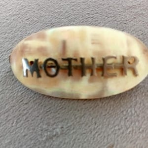 Precioso broche de nácar Art Déco en tono dorado.