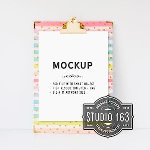 Pode incluir: Uma folha de papel branco de maquete em uma prancheta com um design listrado e de bolinhas coloridas. A prancheta tem um clipe dourado e o papel tem o texto "MOCKUP" e detalhes sobre o tipo de arquivo, a resolução e o tamanho da obra de arte. A imagem também inclui um logotipo em preto e branco com o texto "STUDIO 163".
