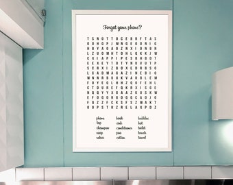 May include: A white framed poster with a black and white word search puzzle. The puzzle is titled "Forgot your phone?" and includes words related to bathroom items such as phone, tap, shampoo, soap, relax, book, sink, conditioner, bubbles, hot, toilet, brush, poo, cotton, and towel.