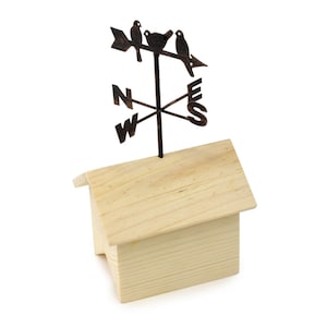 May include: A wooden house with a metal bird weathervane on top. The weathervane has three birds and an arrow pointing to the east. The weathervane also has the letters N, W, E, and S for the cardinal directions.