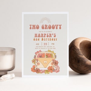 Può includere: Un invito groovy con un font in stile retrò che dice "The Groovy" e "Harper's 2nd Birthday". La carta presenta un furgone Volkswagen vintage decorato con fiori e un segno di pace.