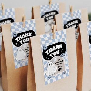May include: Brown paper bags with blue and white checkered thank you tags. The tags feature a ghost illustration and the text "Thank You" in a retro font. The text on the tag also says "For celebrating with us! Love, [Name]"