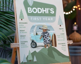 Könnte beinhalten: Eine Holzstaffelei zeigt ein personalisiertes Poster für das erste Jahr eines Kindes. Das Poster zeigt den Namen "Bodhi's" in einem grünen Banner, ein Foto eines Kindes und Details wie Größe (45,7 cm) und Gewicht (12,2 kg).