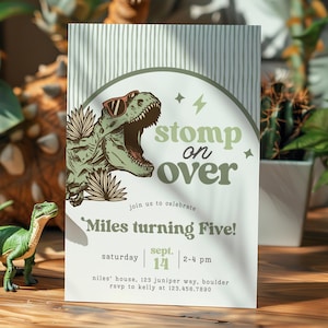 Puede incluir: Una tarjeta de invitaci&oacute;n rectangular con un T-Rex verde con gafas de sol, hojas de palma y el texto "stomp on over" y "Miles turning Five!" con detalles del evento como "saturday sept. 14" y "2-4 pm" en una fuente color verde salvia.