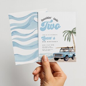 Könnte beinhalten: Eine Geburtstagseinladung mit einem Aquarellwellenmuster auf der Rückseite und einem hellblauen Thema. Die Vorderseite zeigt den Text "truckin' into Two" und einen blauen Oldtimer-Truck mit Surfbrett. Die Einladung ist für Lucas 2. Geburtstag.