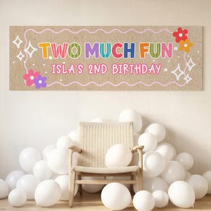 Könnte beinhalten: Ein rechteckiges Banner mit beigem Hintergrund und dem Text TWO MUCH FUN sowie ISLA'S 2ND BIRTHDAY in bunten Buchstaben. Das Design enthält rosa Wellenränder, weiße Sternformen sowie kleine rote, orange, rosa und violette Blumenmotive.