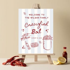 May include: A blue and white striped sign with red text that says "Welcome to the Wilson Family Crawfish Boil" and the date "August 10, 20XX". The sign also features illustrations of crawfish, corn on the cob, a bottle of hot sauce, and a pot of crawfish.