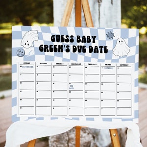 May include: A white and blue checkered sign with the text "Guess Baby Green's Due Date" and a calendar grid with dates from September 24th to October 6th. The sign has a ghost and a smiley face graphic.