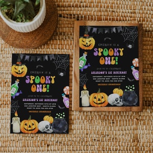 May include: Two black and white Halloween party invitations with a spooky theme. The invitations feature a black background with a purple and green "Spooky One!" text. The invitations also feature a pumpkin, a cauldron, a skull, and a spider web.