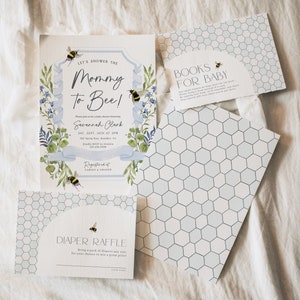 Può includere: Un invito a una festa di benvenuto per il bambino con tema delle api. L'invito è decorato con illustrazioni floreali blu e verdi e api. Il testo dell'invito recita "Let's shower the Mommy to Bee!" e include la data, l'ora e il luogo della festa. L'invito include anche una richiesta di libri per il bambino e una lotteria di pannolini.
