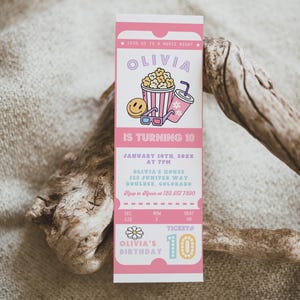 Peut inclure: Invitation rose en forme de billet de cinéma pour le 10e anniversaire d'Olivia. Le design comprend des illustrations de pop-corn, d'une boisson et de lunettes 3D. L'invitation comprend la date, l'heure et le lieu de la fête.