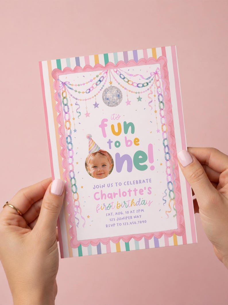K&ouml;nnte beinhalten: Eine rechteckige Geburtstagseinladungskarte mit rosa gewelltem Rand und vertikalen Pastellstreifen. Das Design zeigt eine Discokugel, h&auml;ngende Ketten, Sterne und den Text: it's fun to be one! Join us to celebrate Charlotte's first birthday.
