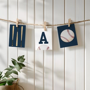 Peut inclure: Trois cartes imprimables suspendues &agrave; une ficelle avec des pinces &agrave; linge. Les cartes sont bleu marine avec des accents blancs. La premi&egrave;re carte a deux battes de baseball, la deuxi&egrave;me carte a la lettre A et la troisi&egrave;me carte a un ballon de baseball.