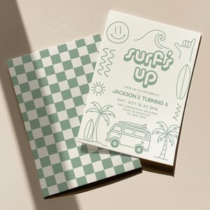 May include: Two invitation cards with a surfing theme. One has a green and white chequered pattern. The other card features the text "Surf's Up" with illustrations of a surfboard, palm trees, and a van.