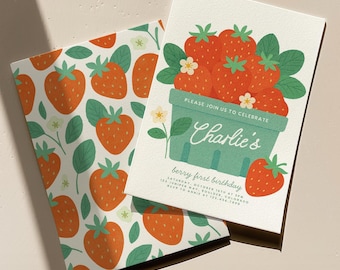 Puede incluir: Dos tarjetas con temática de fresas. Una tarjeta presenta una cesta de fresas rojas con hojas verdes y el texto "Charlie's berry first birthday". La otra tarjeta tiene un patrón de fresas y hojas.