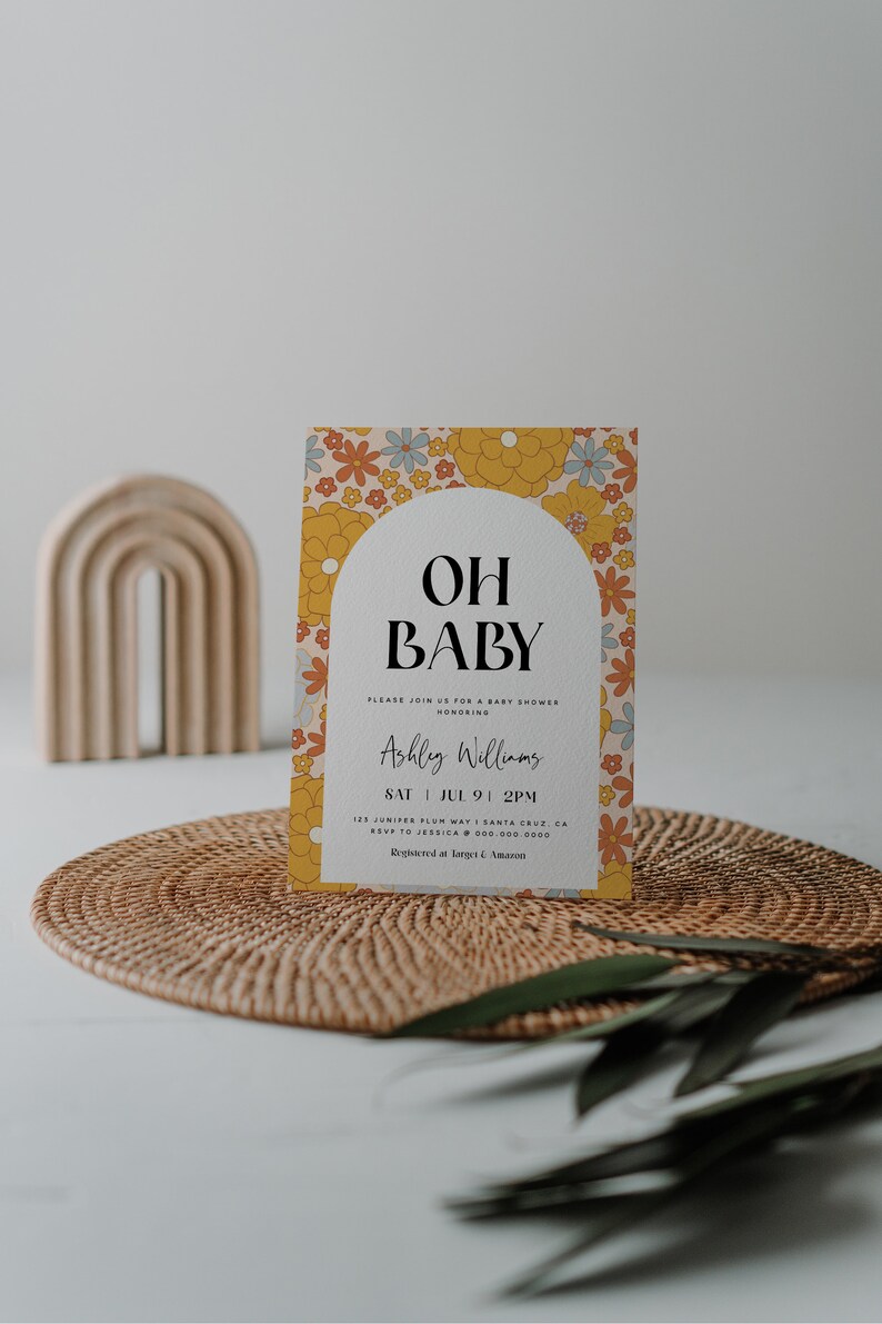May include: A baby shower invitation with a floral pattern in shades of yellow, orange, and blue. The text reads "Oh Baby" and includes the name "Ashley Williams", the date "Sat Jul 9 1 PM", and the address "125 Juniper Plum Way, Santa Cruz, CA". The invitation also includes the RSVP information and the registry information.